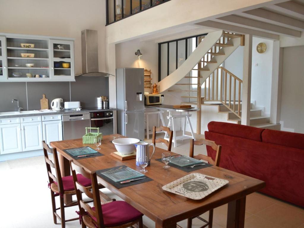 eine Küche und ein Esszimmer mit einem Holztisch in der Unterkunft Gîte Saint-Sulpice-de-Cognac, 2 pièces, 2 personnes - FR-1-653-139 in Saint-Sulpice-de-Cognac