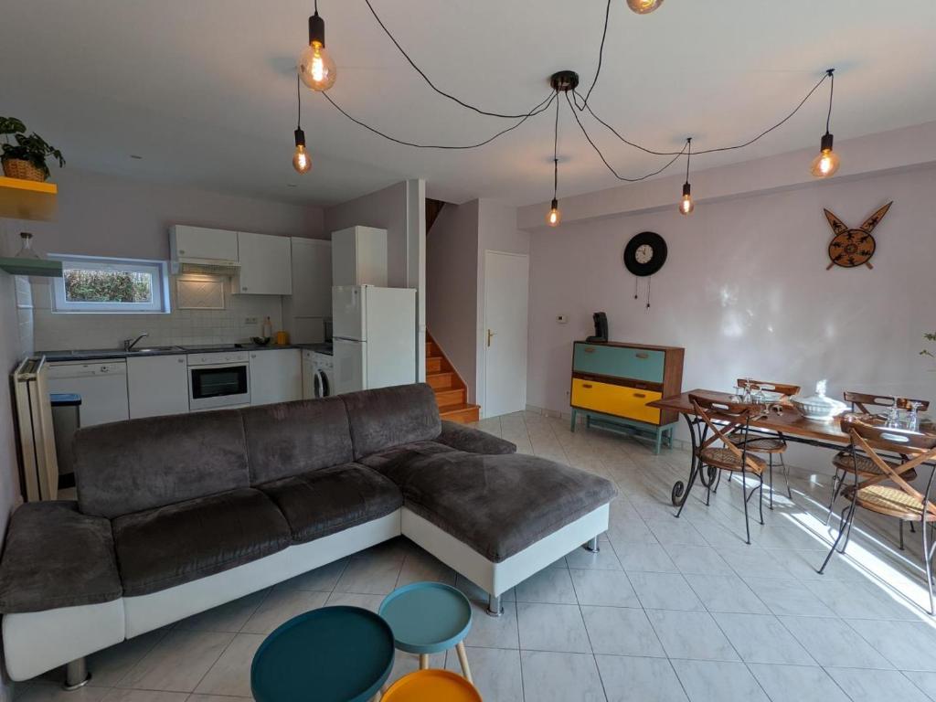 un salon avec un canapé et une cuisine dans l'établissement Gîte familial avec piscine chauffée et wifi, au cœur de la nature, proche Chadurie, Charente - FR-1-653-172, à Montmoreau