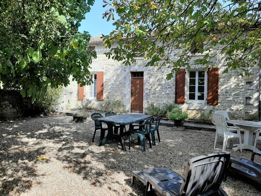 a table and chairs in front of a stone building at Gîte Champniers, 3 pièces, 4 personnes - FR-1-653-198 in Champniers