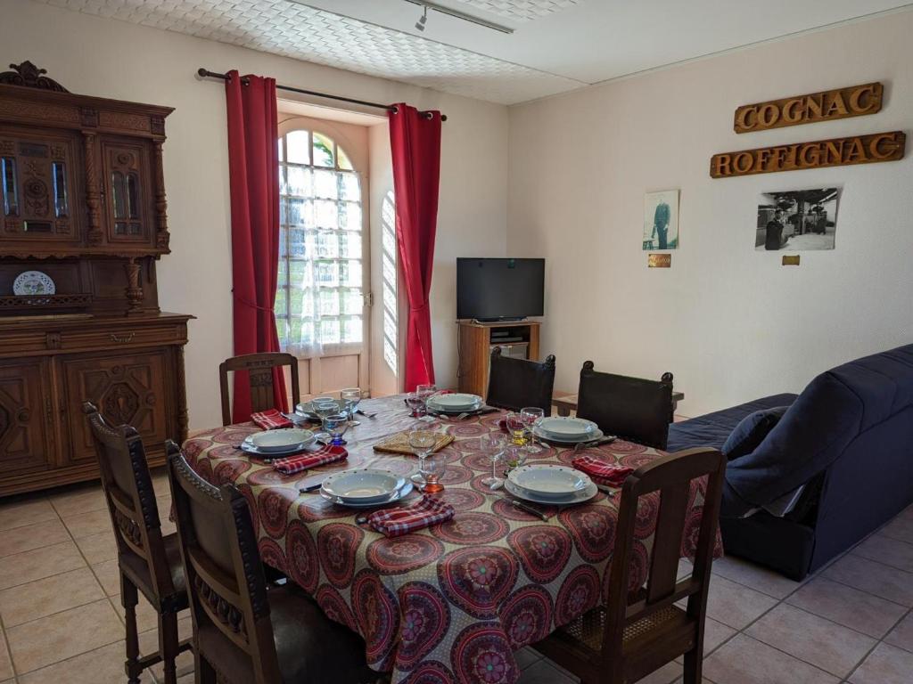 a dining room with a table with chairs and a tableablish at Gîte Cherves-Richemont, 3 pièces, 5 personnes - FR-1-653-205 in Cherves-de-Cognac