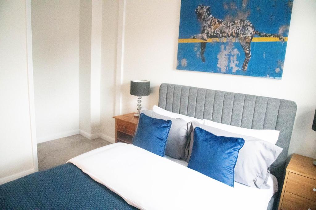 a bedroom with a bed with blue and white pillows at Lovely 1 bedroom Apartment High Wycombe in Buckinghamshire
