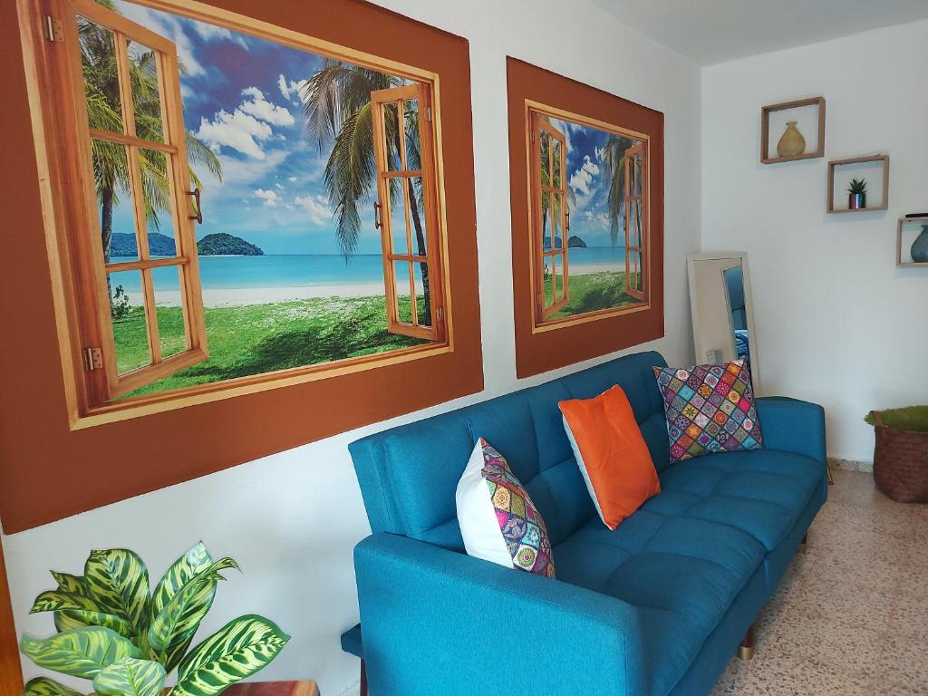 a blue couch in a living room with windows at Casa Doña Guilla 2 