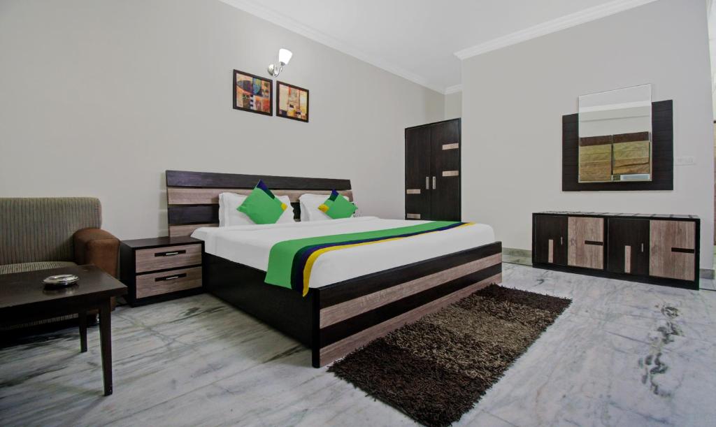 a bedroom with a large bed and a couch at Treebo Trend Maharaja Residency in Jaipur