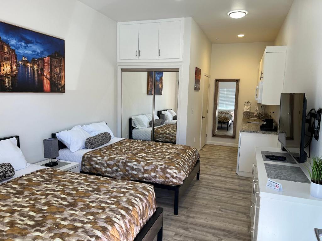 a hotel room with two beds and a kitchen at Villa Alamari Inn and Suites in Kerman