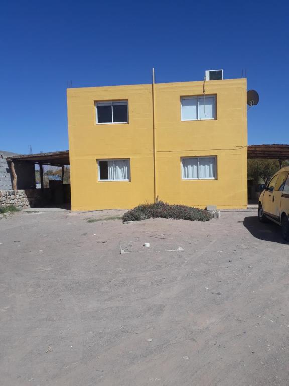 un edificio amarillo frente a un aparcamiento en Colores de Fiambala en Fiambala