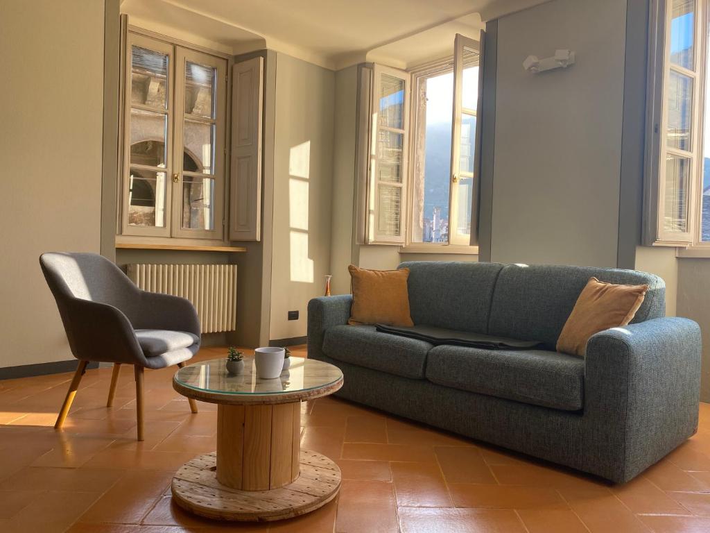 uma sala de estar com um sofá e uma mesa em Antica Dimora del Mercato em Domodossola