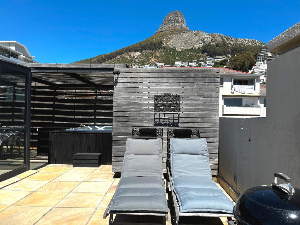 a patio with two beds on top of a building at Namaste in Cape Town
