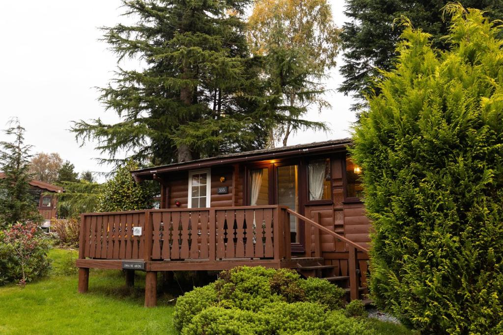 a wooden cabin in the middle of a yard at Mountain View Log Cabin - Snowdonia in Tanygrisiau