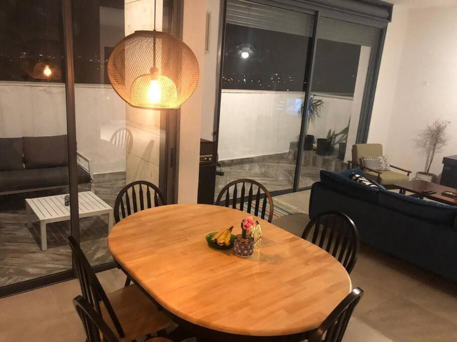 ラーナナにあるStunning four bedroom duplex in central Raananaのリビングルーム(木製テーブル、椅子付)