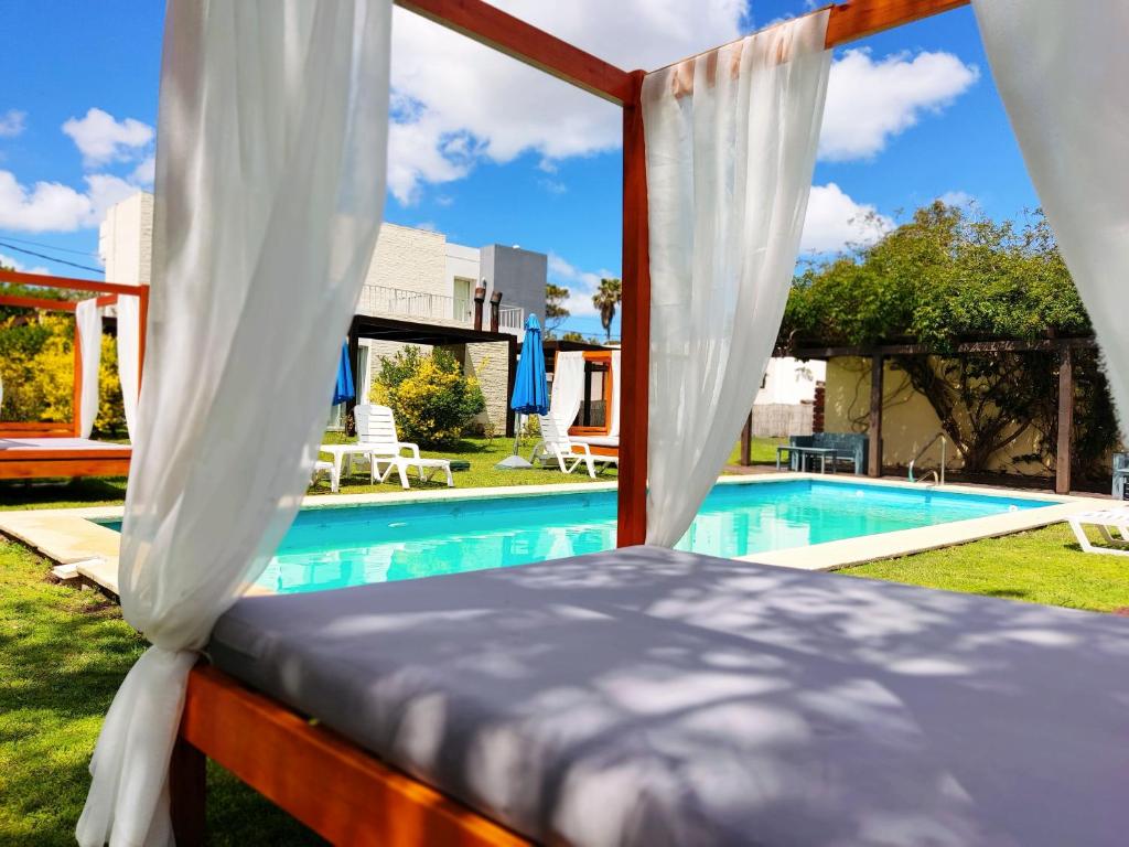 a bedroom with a canopy bed next to a swimming pool at Las Martinas Piriapolis in Piriápolis