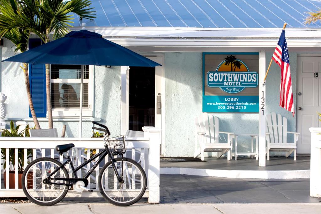 een fiets geparkeerd voor een huis met een paraplu bij Southwinds Motel in Key West