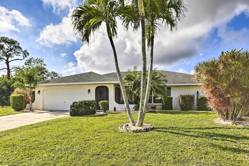 a house with two palm trees in a yard at Cape Coral Home with Gulf and Dock Access in Cape Coral