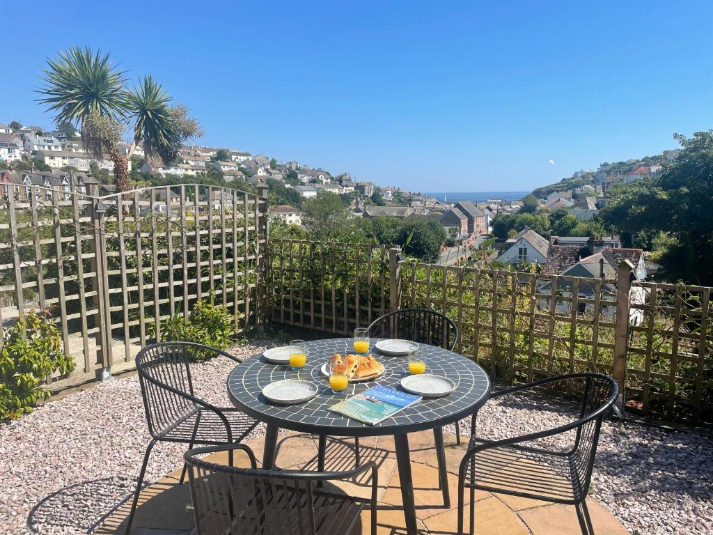 una mesa y sillas en un patio con vistas en Mevagissey Holiday Home - sea view and parking, en St Austell