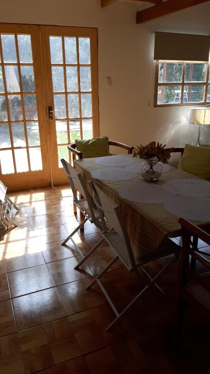 comedor con mesa, sillas y ventanas en Cabaña VILLA ANGÉLICA-LUNAHUANA, en Lunahuaná