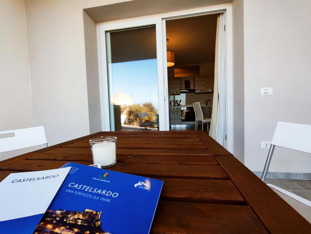 a table with a book and a glass of milk on it at Casa Alexandra in Castelsardo