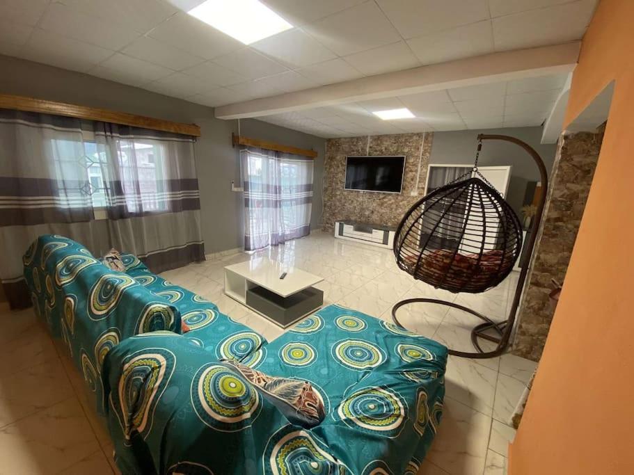Logement 2 chambres au sud de Mayotte في Bouéni: غرفة معيشة مع أريكة زرقاء في غرفة