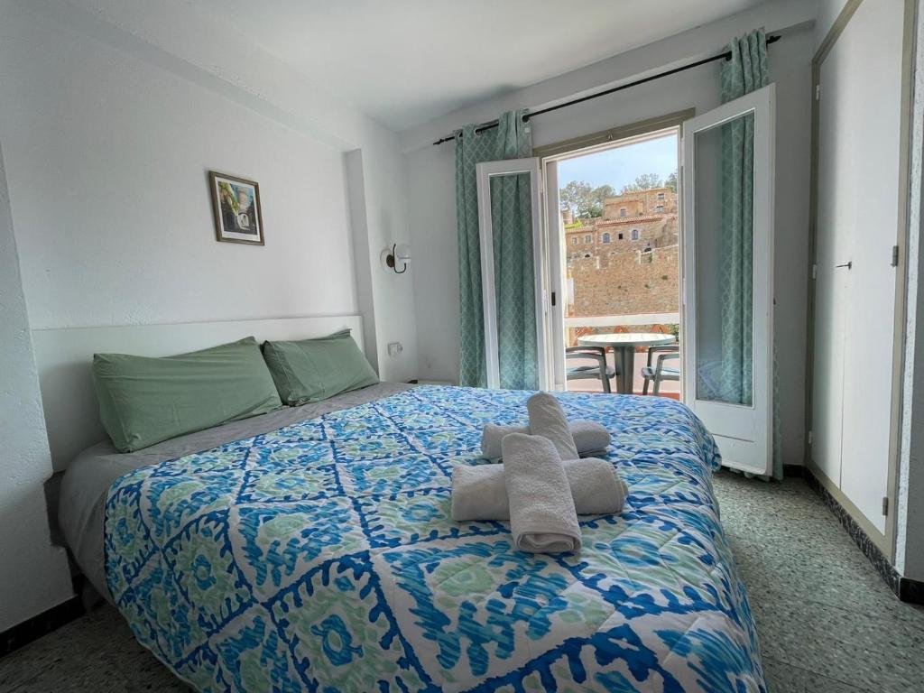 ein Schlafzimmer mit einem Bett mit einem ausgestopften Tier darauf in der Unterkunft P&R hostals Maria Rosa in Tossa de Mar