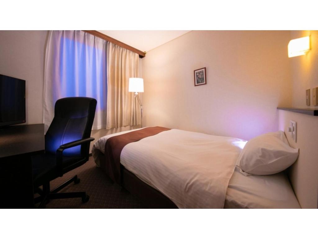 a hotel room with a bed and a desk and a chair at Ninohe City Hotel - Vacation STAY 36054v in Ninohe