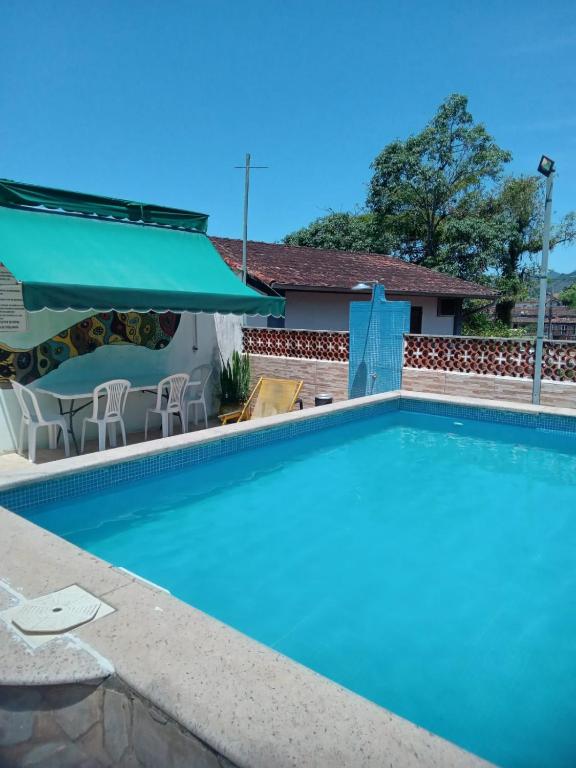 una piscina con agua azul frente a una casa en Leo&#39;s Clan Beach Hostel, en Paraty