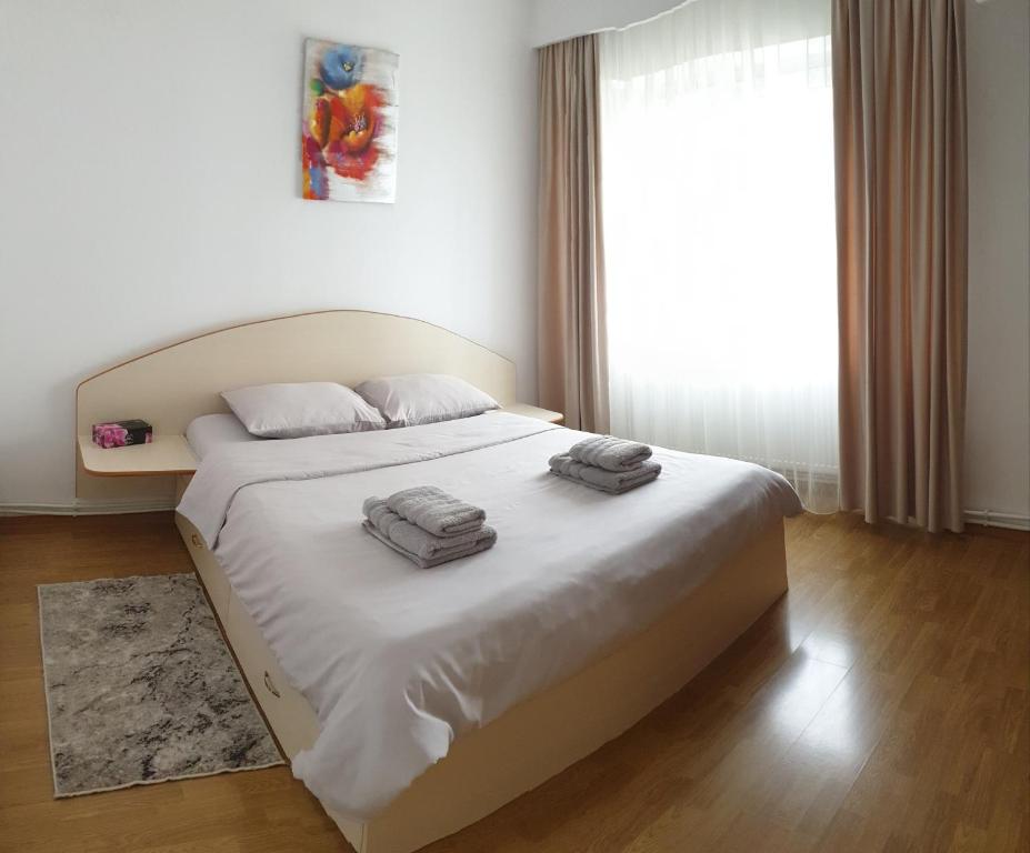 a bedroom with a bed with two towels on it at Vio apartament in Zalău