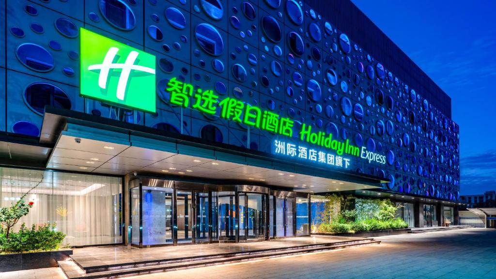 un bâtiment avec un panneau sur son côté dans l'établissement Holiday Inn Express Cangzhou High-Tech Zone, an IHG Hotel, à Cangzhou