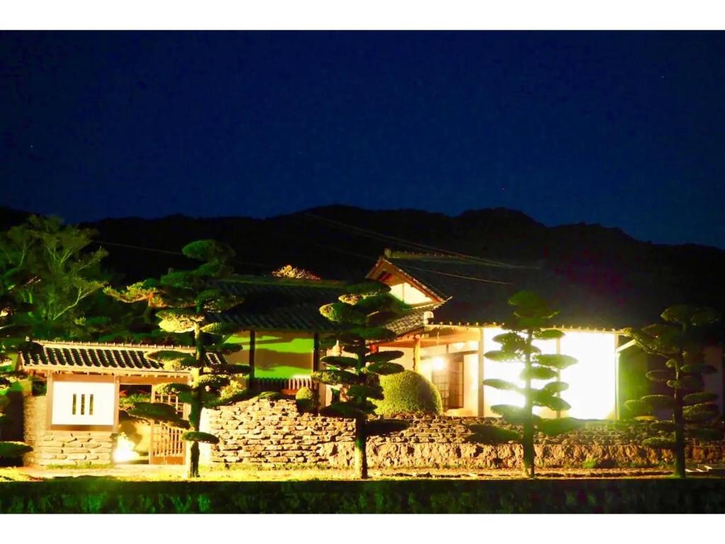 a house at night with a stone wall at Yadoya Sho - Vacation STAY 13531 in Kurume