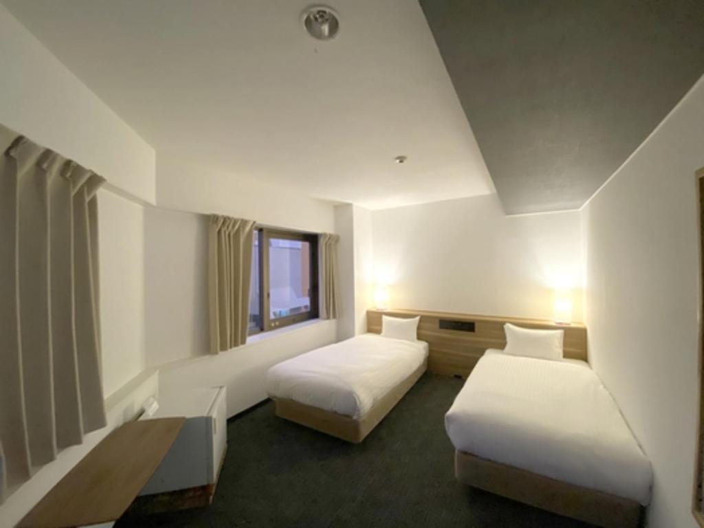 a hotel room with two beds and a window at Santiago Hotel - Vacation STAY 74128v in Hiroshima