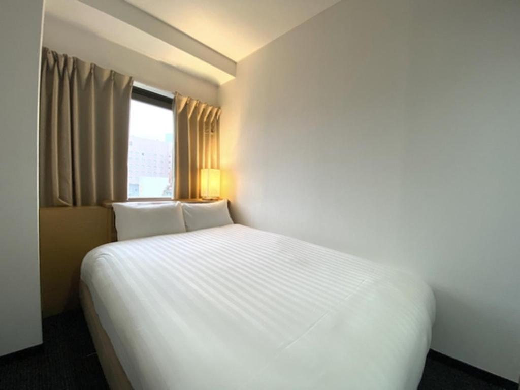 a white bed in a room with a window at Santiago Hotel - Vacation STAY 74126v in Hiroshima