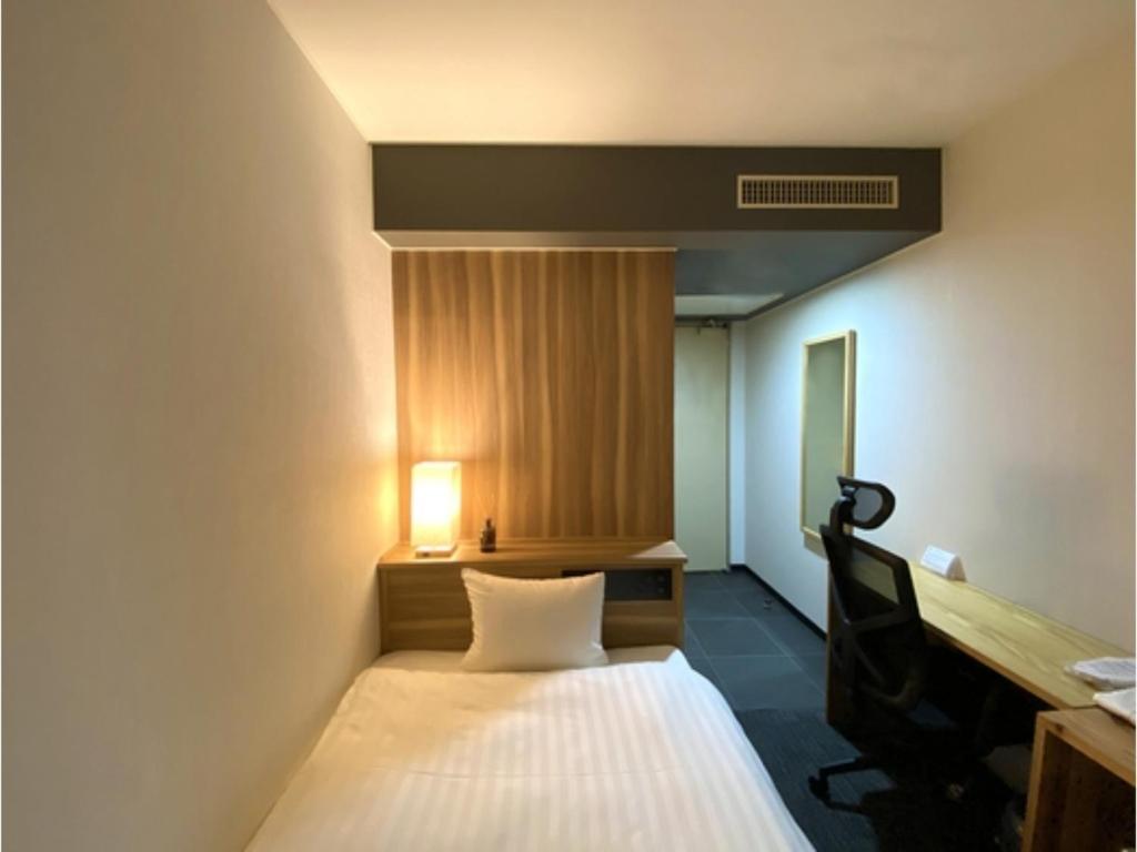 a small room with a bed and a desk at Santiago Hotel - Vacation STAY 74090v in Hiroshima