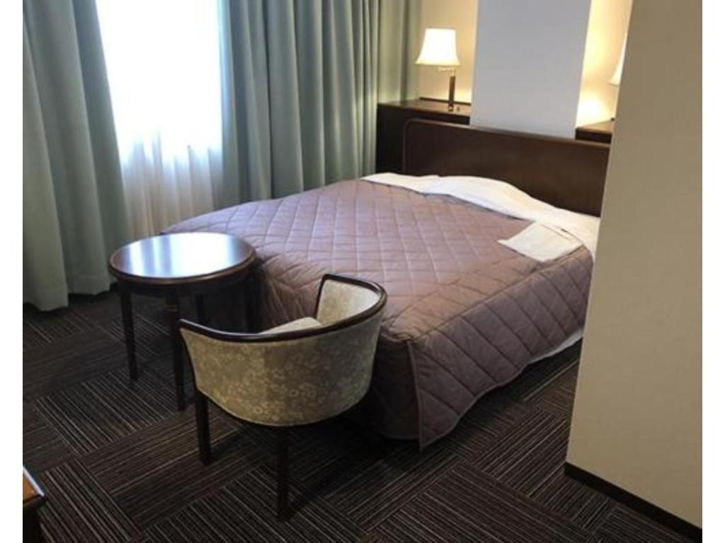 a hotel room with a bed and a table and a chair at Urban Hotel Nihonmatsu - Vacation STAY 78342v in Nihommatsu