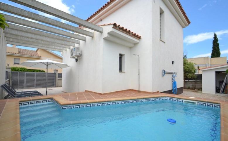 a swimming pool in front of a house at Villa Joan in Riumar