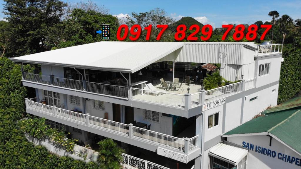 a large white building with a clock on top of it at Victoria's Bed & Breakfast in Puerto Galera