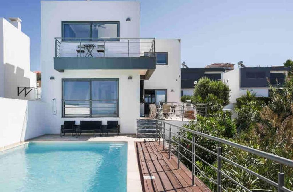 a house with a swimming pool and a balcony at Casa Amour Villa in Lourinhã