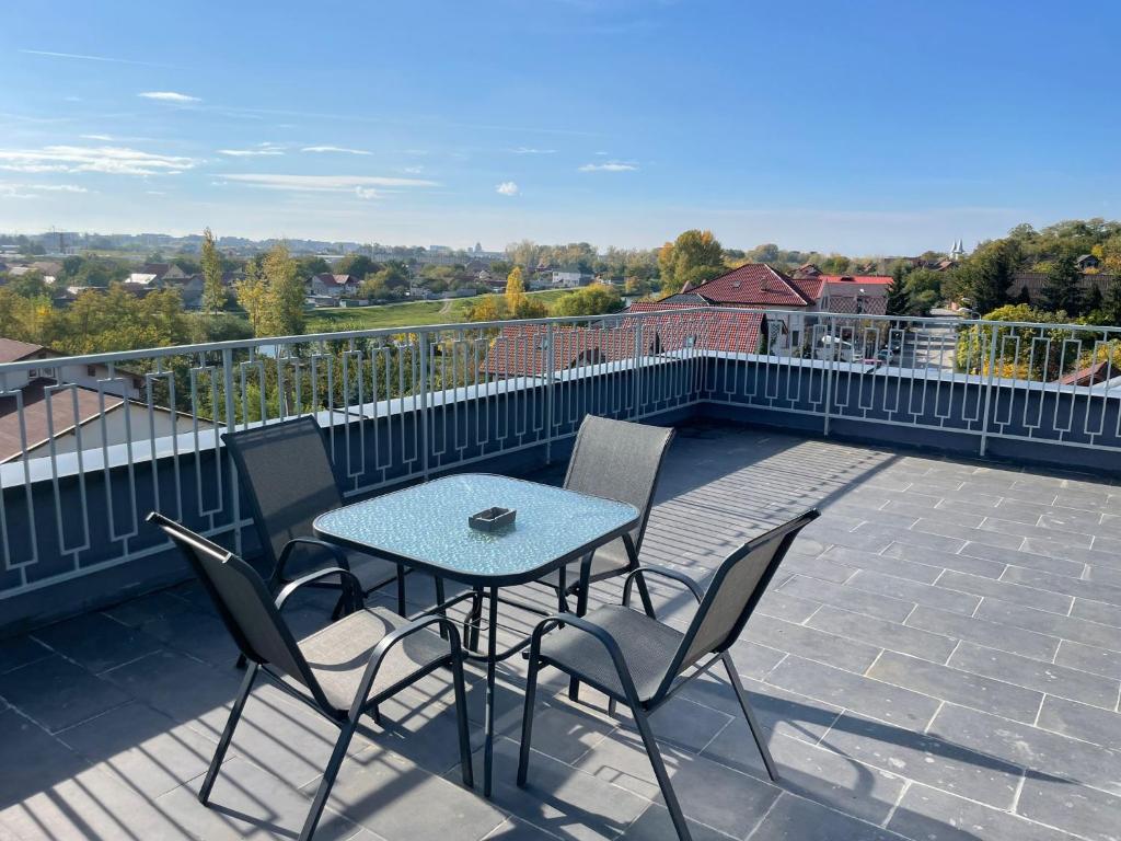 een patio met een tafel en stoelen op een balkon bij Penthouse DH Apartments in Oradea