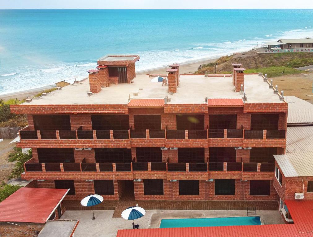a building with a swimming pool and the beach at Hotel International in Pedernales