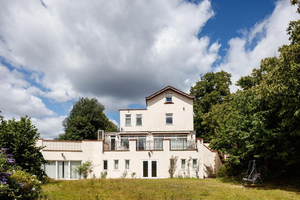 a large white house on a hill with trees at Beautiful 'Mayfield' Villa with private pool! in Manchester