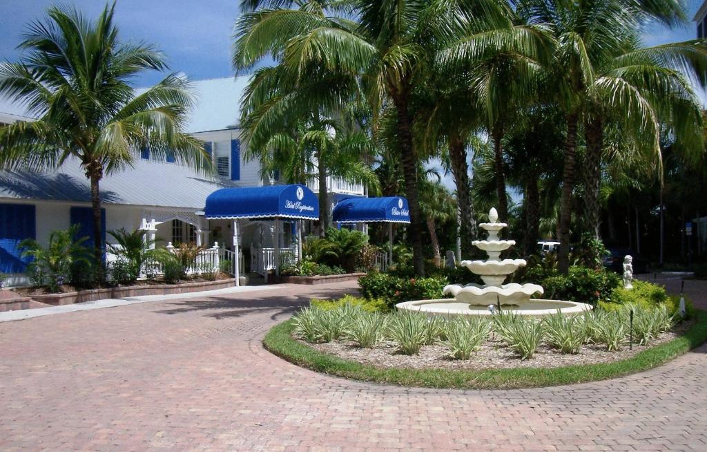 a fountain in the middle of a courtyard with palm trees at Olde Marco Island Inn and Suites in Marco Island