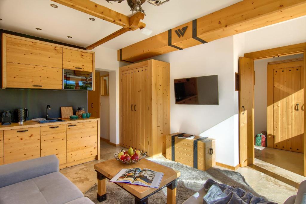 - un salon avec des placards en bois et un canapé dans l'établissement Apartament Wypas, à Kościelisko