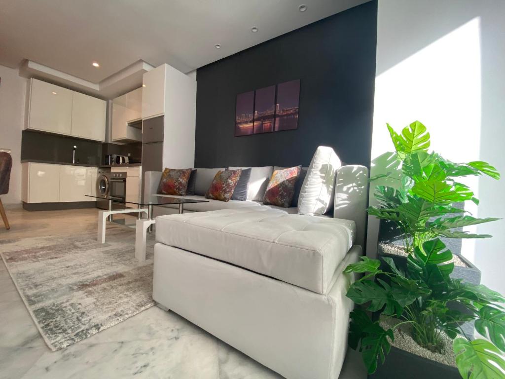 a living room with a white couch and a kitchen at CORNICHE CASABLANCA - SUBLIME F2 NEUF in Casablanca
