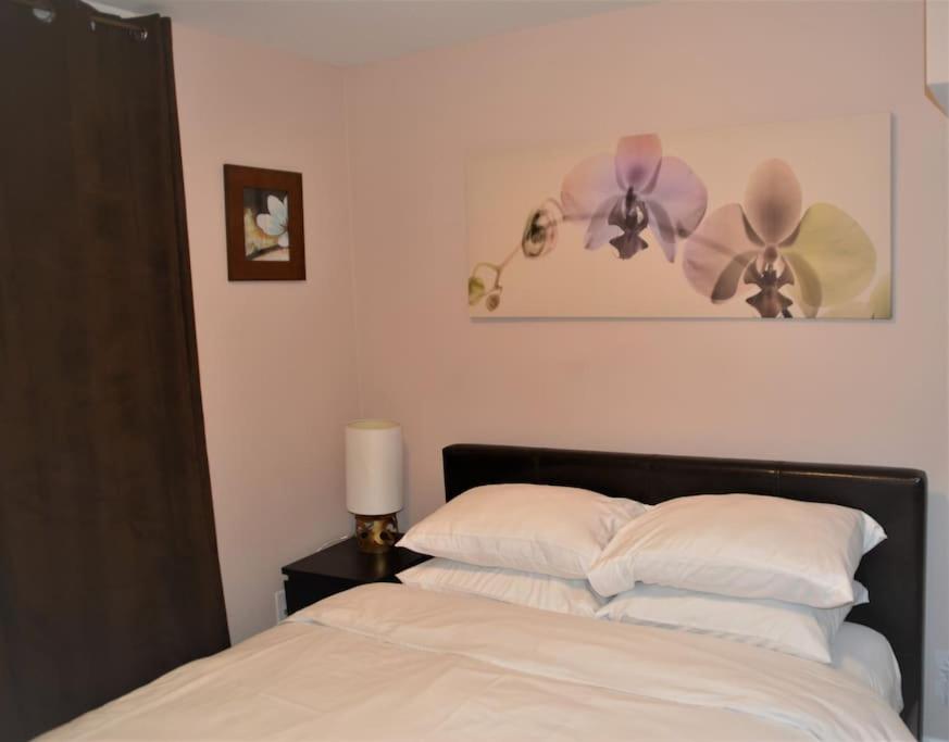 a bedroom with a bed with white pillows and two ceiling fans at Beautiful and spacious Apartment in Brampton