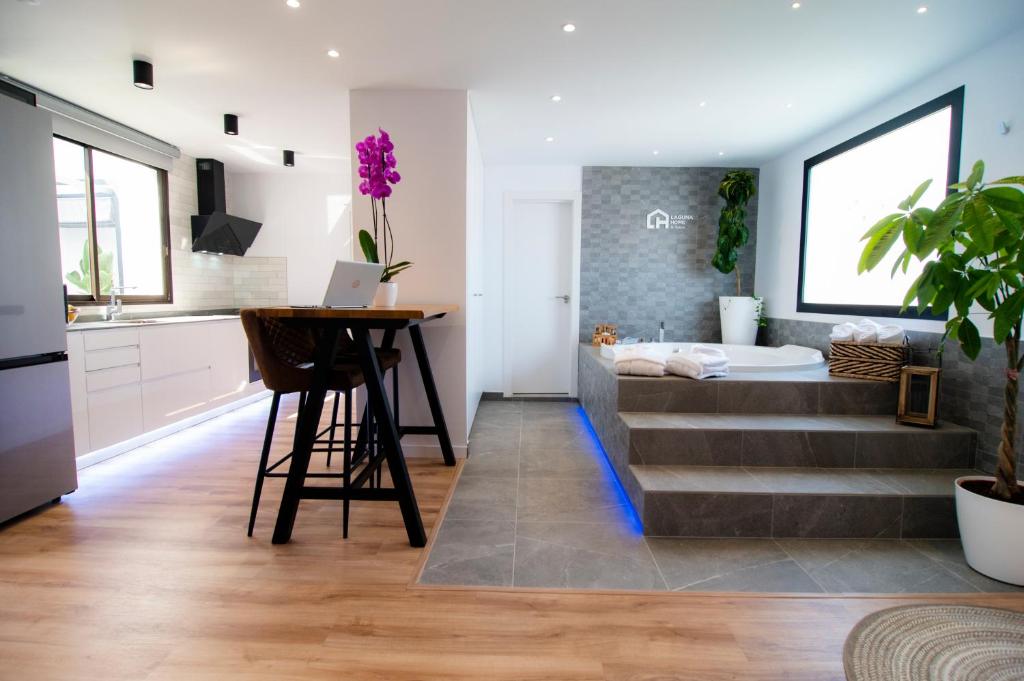 kuchnia i salon z łóżkiem i stołem w obiekcie Laguna Home & Suites w mieście La Laguna