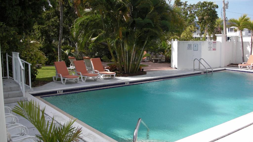 a swimming pool with lounge chairs next to a house at Olde Marco Island Inn and Suites in Marco Island