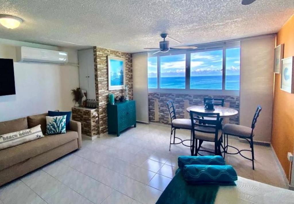 a living room with a couch and a table with chairs at KASA Emmas Ocean View in San Juan