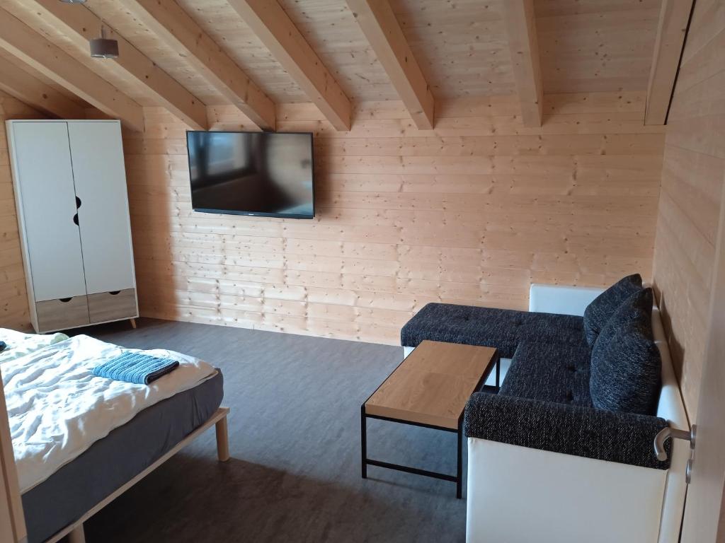 a bedroom with a bed and a tv on a wall at Ferienwohnung Fernweh in Bolsterlang