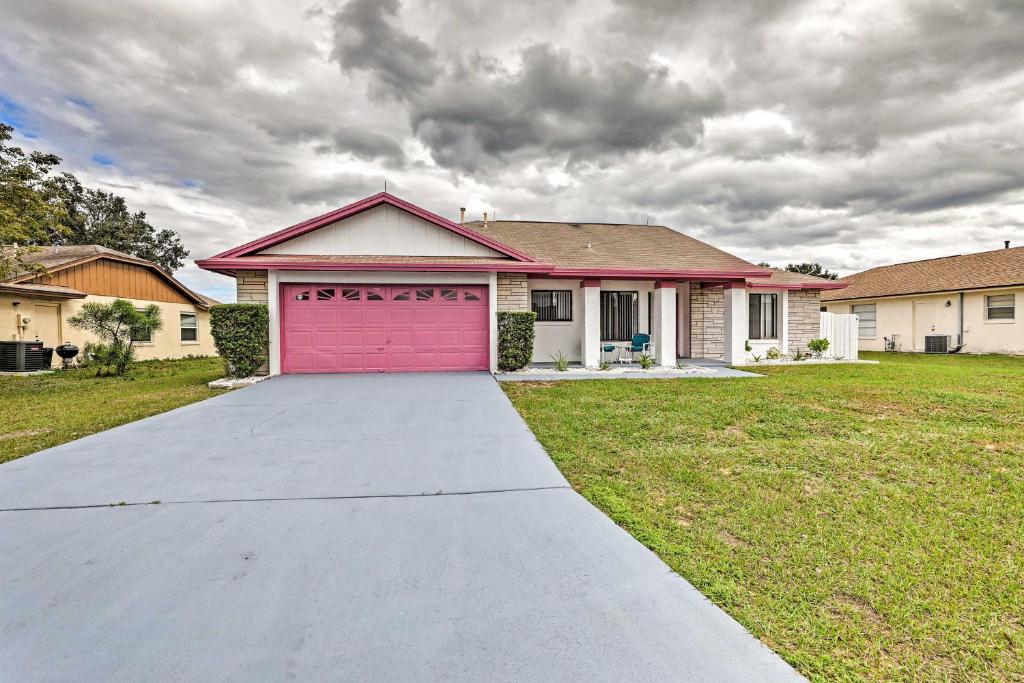 a house with a pink garage in a yard at Kissimmee Home with Game Room, 7 Mi to Disney Parks! in Orlando