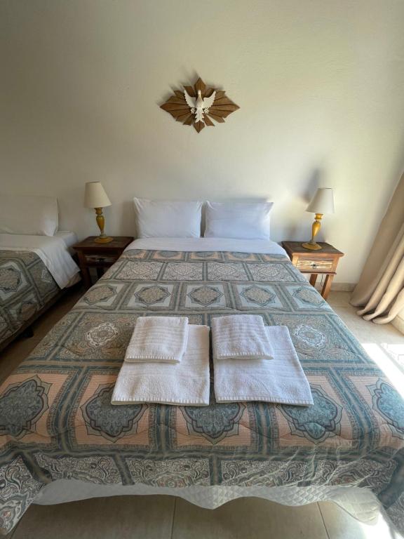 a bedroom with a large bed with two towels on it at Sobrado Torre in Tiradentes