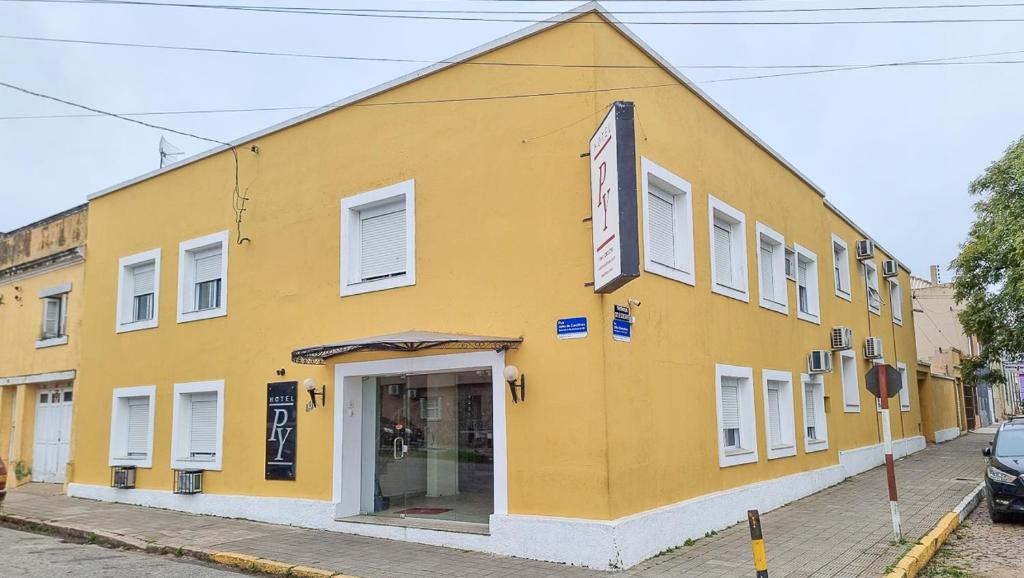 ein gelbes Gebäude an der Straßenseite in der Unterkunft hotel py jaguarão in Jaguarão