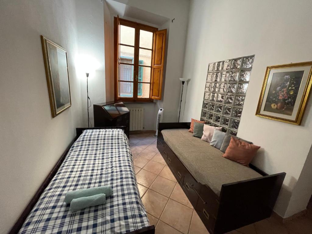a living room with two beds and a window at Artemisia in Pisa