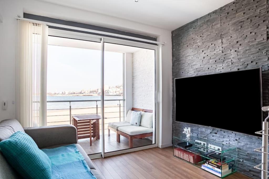 a living room with a large flat screen tv at Cabanon avec terrasse - bord de plage - Le Cabanon 12 in Marseille