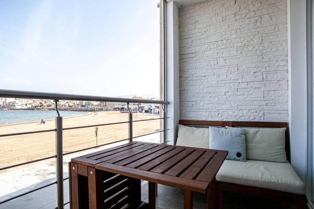 a balcony with a bench and a view of the beach at Cabanon avec terrasse - bord de plage - Le Cabanon 12 in Marseille